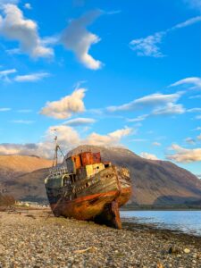 Kaldale uhutud kalalaev Ben Nevise taustal, päikeseloojang. Šotimaa loodusmatk - Põhja-Šoti mägismaa reis, aprill 2025